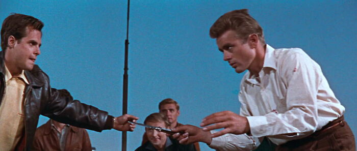 Two men in a tense standoff over a knife, depicting a story about famous movie props.