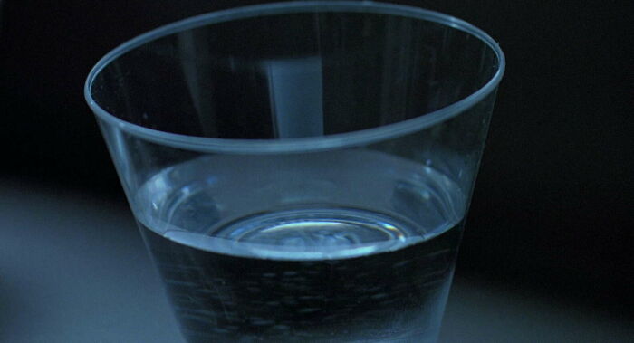 A famous movie prop, a plastic cup filled with water, reflecting light in a dimly lit scene.