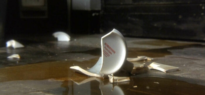 Broken coffee mug prop on wet floor, part of famous movie props stories.