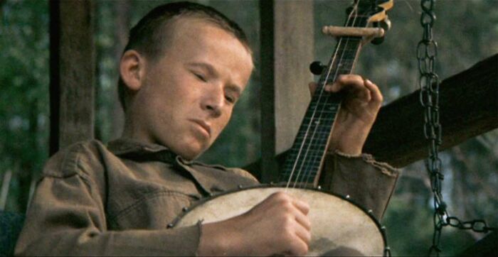 A person playing a banjo outdoors, a famous movie prop from a classic film scene.
