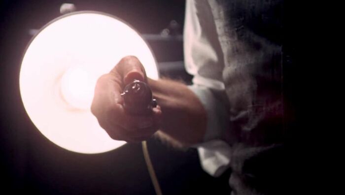 Hand holding a classic movie prop against a bright light, highlighting famous movie props stories.