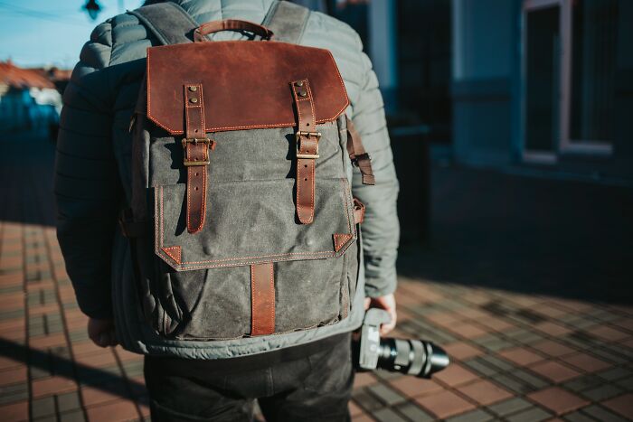 Traveler with essentials: a stylish backpack and a camera for easier, more peaceful journeys.