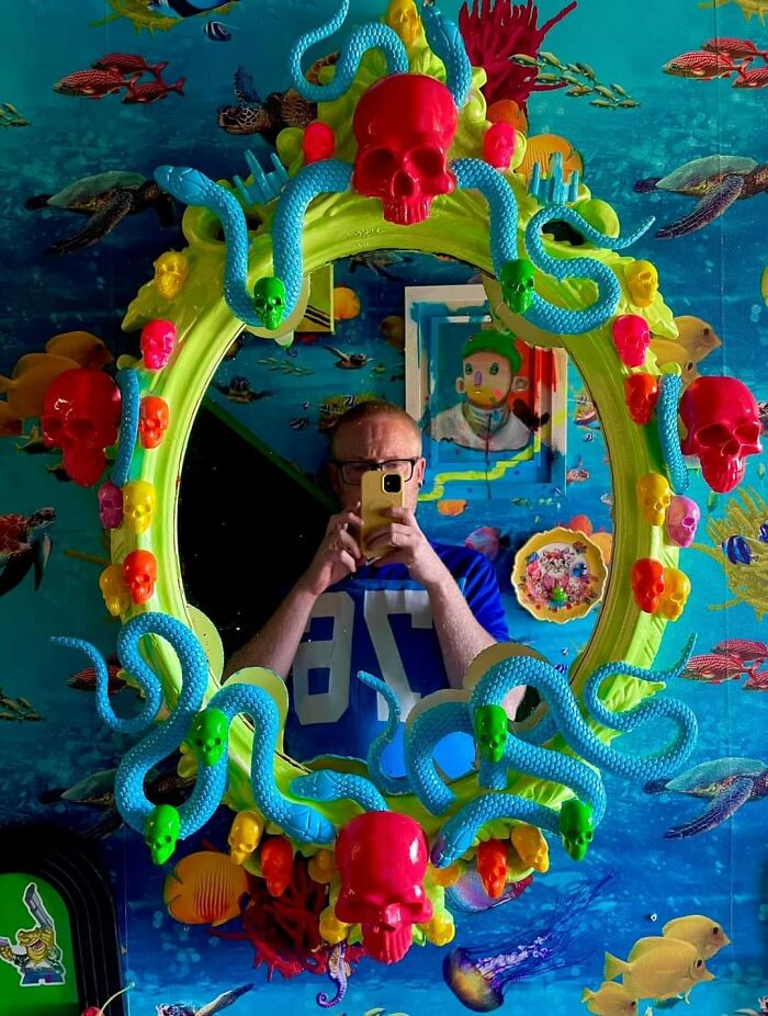 Colorful DIY mirror frame with bright skulls and snakes.