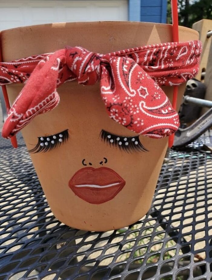 Clay pot with painted face and red bandana, part of craft shaming DIY projects.