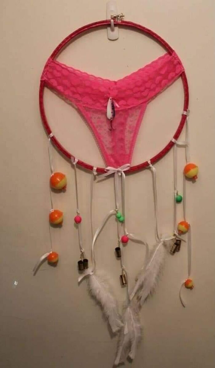 DIY craft project with pink lace, feathers, and dangling items on a hoop, showcasing creativity that needs to be shamed.