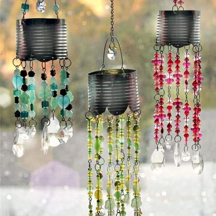 DIY craft project using tin cans and colorful beads hanging as decor.