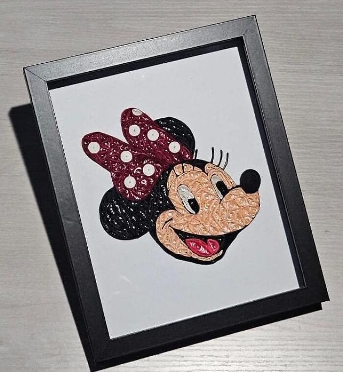 Framed craft project of a character made from coiled materials, showcasing a creative DIY attempt.