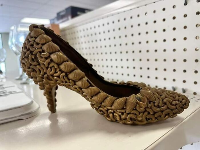 DIY project shoe covered in glued pasta shells on a store shelf.