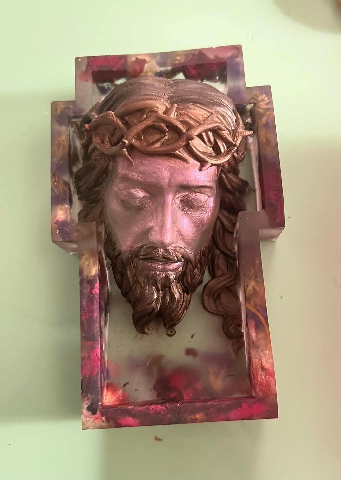 Horrendous DIY project of a cross-shaped resin mold featuring a textured head with a crown of thorns.