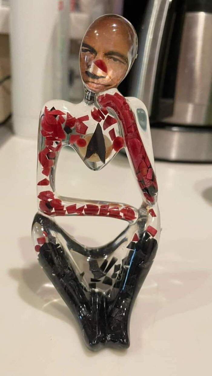 Horrendous DIY project with red and black mosaic on a glass figure, featuring a misaligned face.