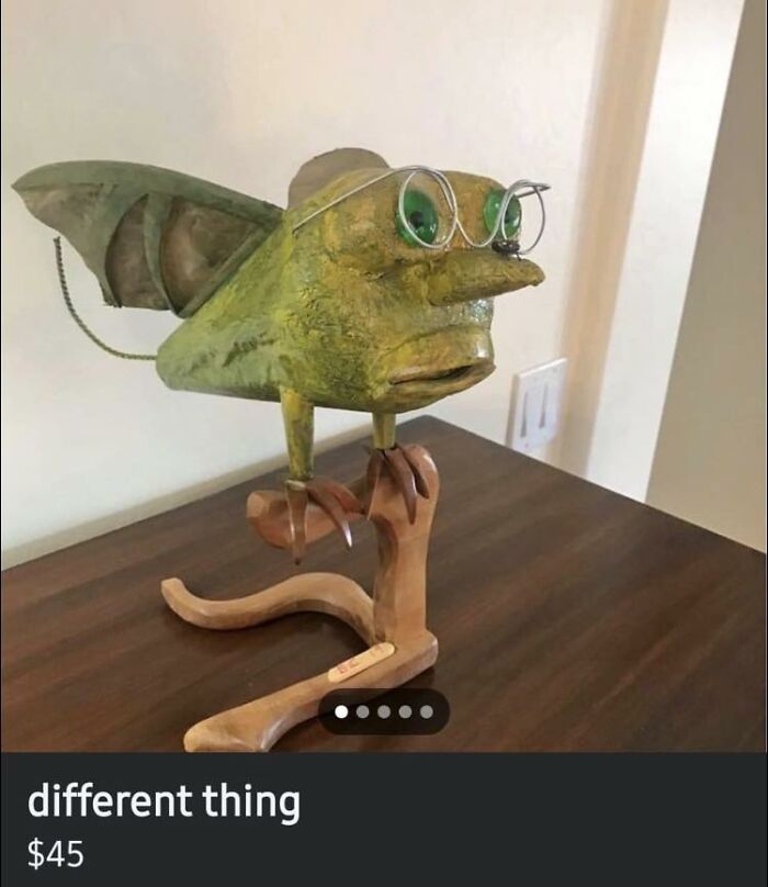 Bizarre DIY project of a creature with glasses on a wooden stand.
