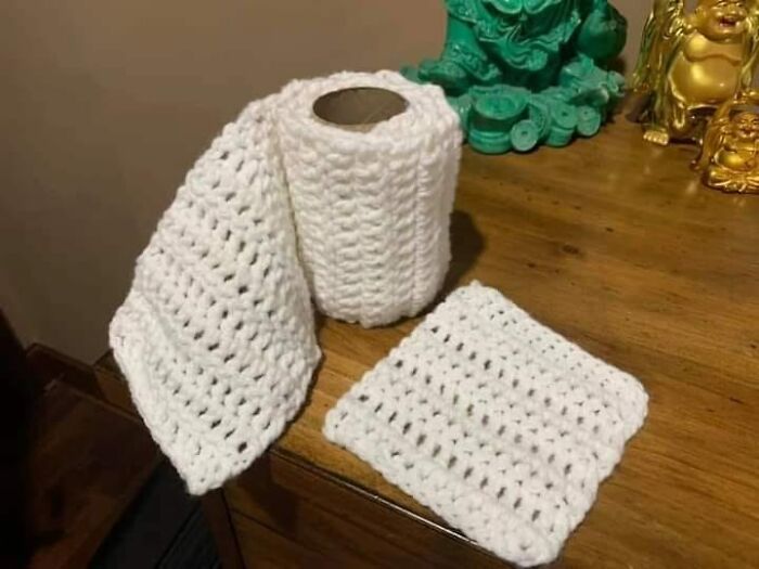 Crocheted toilet paper DIY project on a wooden table, showcasing a humorous craft fail.