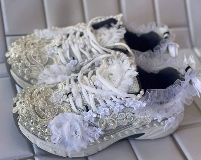 DIY project gone wrong: sneakers covered in excessive lace, pearls, and frills, creating an over-the-top design.