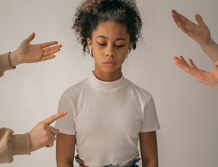 Teenager facing criticism, surrounded by pointing fingers, representing babysitting responsibilities conflict.