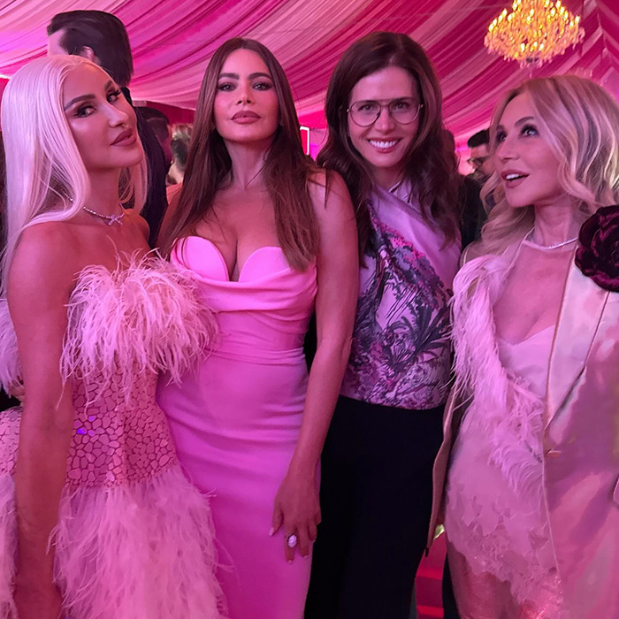 Sofia Vergara posing with friends in glamorous pink outfits at Paris Hilton's birthday party, under a decorated canopy.