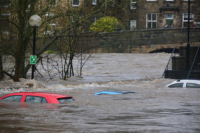 Severe flooding with submerged cars near a bridge, highlighting critical things everyone should know about flood safety.