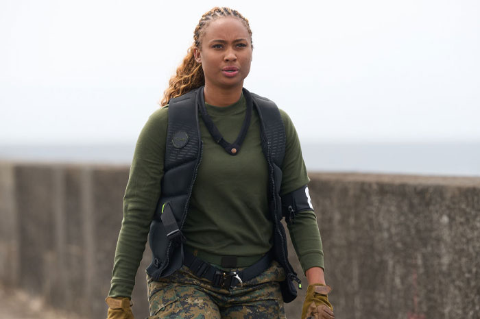 Kayla Nicole in tactical gear on a mission, dressed in green with camouflage pants. "Special Forces" season 3 star.