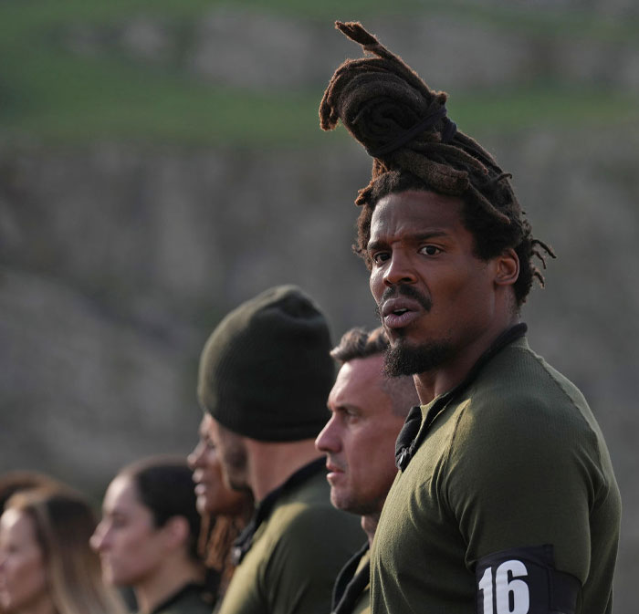 Stars of Special Forces Season 3 including Cam Newton line up outdoors, wearing military gear and number armbands.