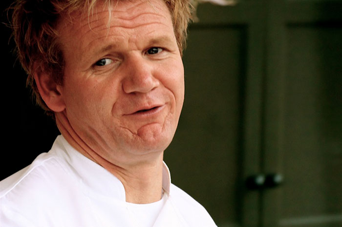 A chef in a white coat, possibly discussing signs of a bad restaurant, with a serious expression.