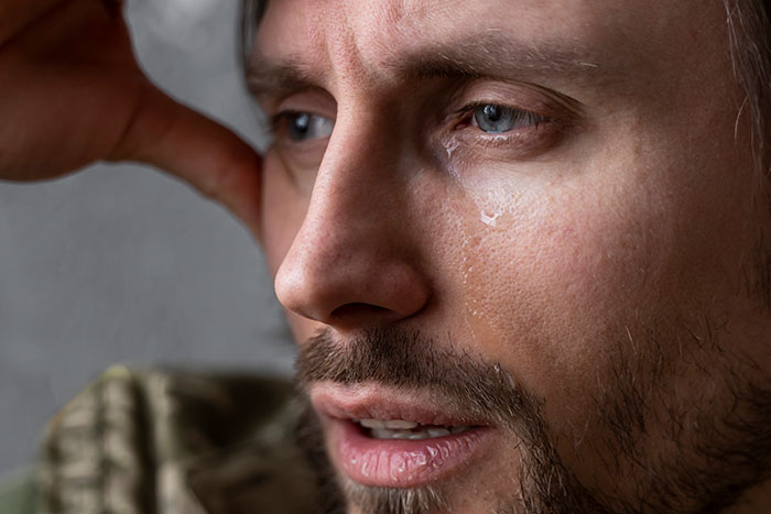 Man in deep thought with a tear on his cheek, illustrating surprising emotions.