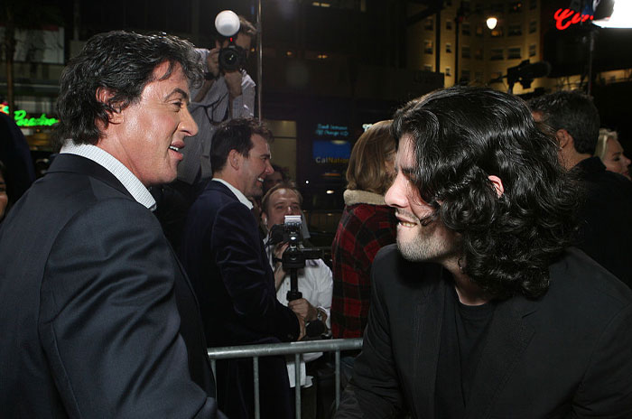 Sylvester Stallone with his child Sage Stallone at a glamorous event, surrounded by photographers and fans.