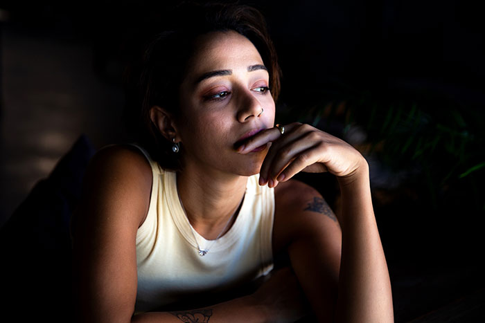 Teen reflecting while prioritizing her future, deep in thought indoors.