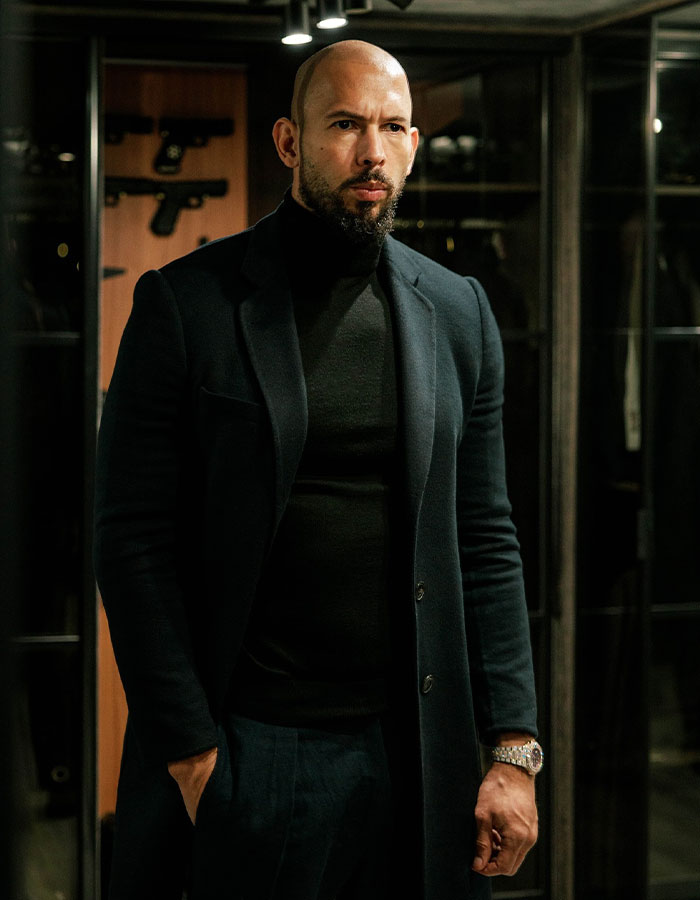 Man in dark clothing standing indoors, related to deportation and trafficking charges.