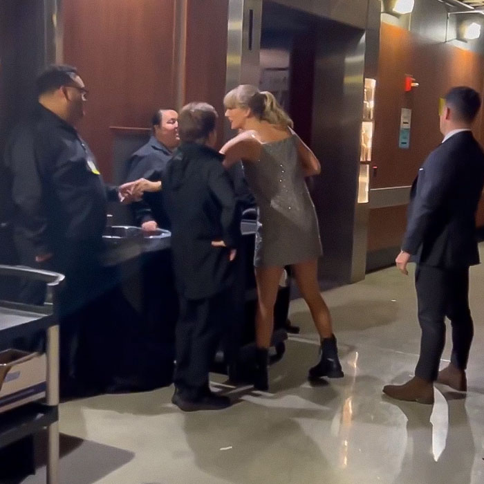 Taylor Swift in a silver dress, interacting with staff and giving tips in cash at the Grammys.