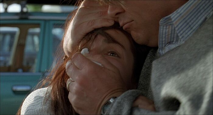 A dramatic movie moment showing a man holding a woman's face, highlighting an unrealistic scenario.
