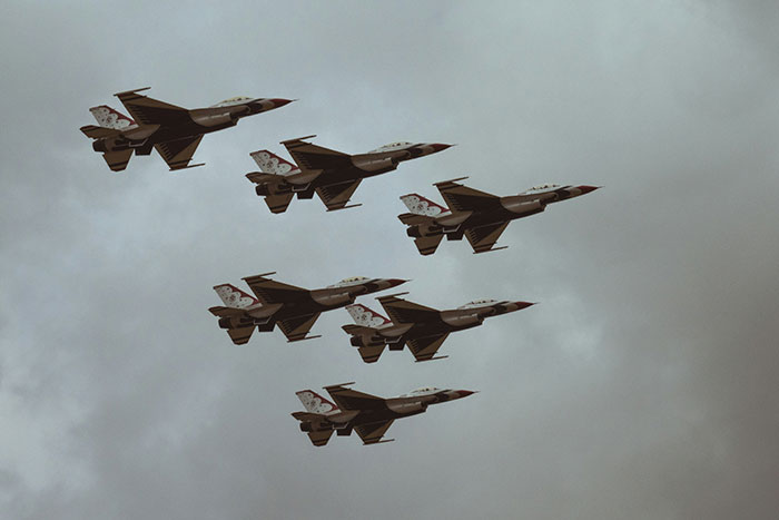Jet fighters in formation against a cloudy sky, illustrating precision and teamwork.