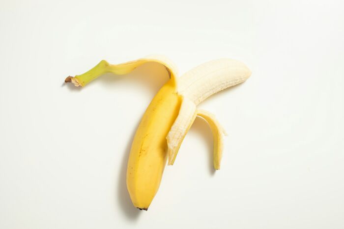 Peeled banana on a white background, representing topics men shouldn't be judged for.