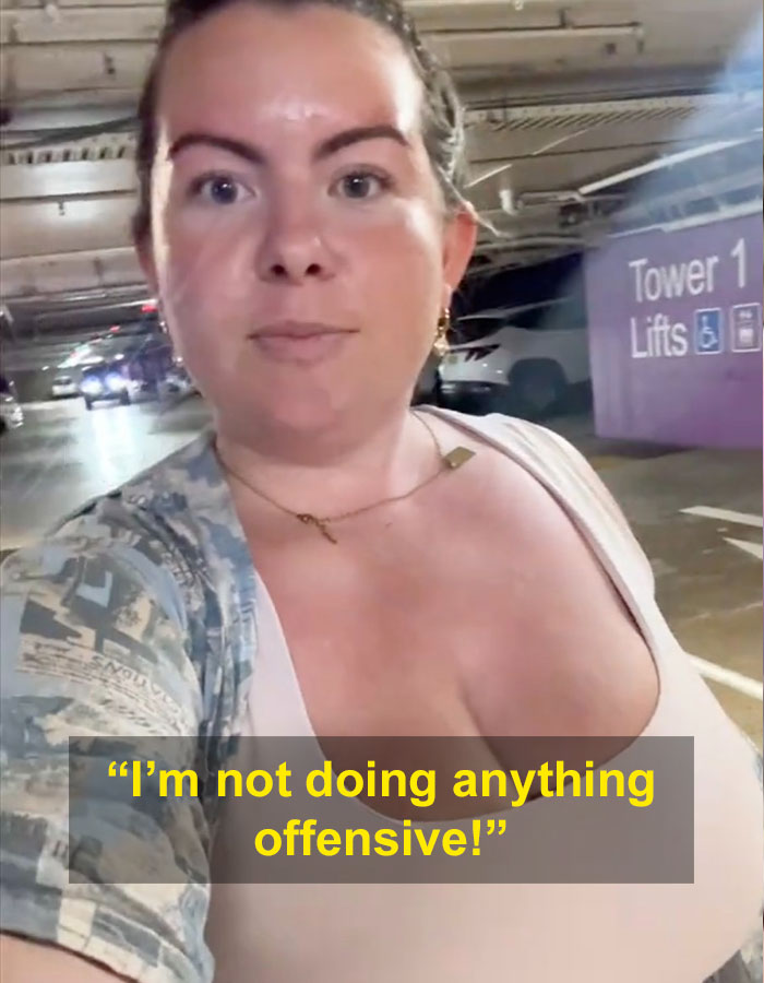 Woman with G-cup responding to stares in a parking structure, text overlay saying &ldquo;I&rsquo;m not doing anything offensive!&rdquo;