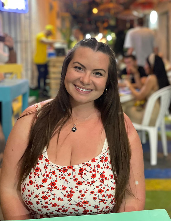 Woman smiling in a floral dress, addressing attention from strangers.