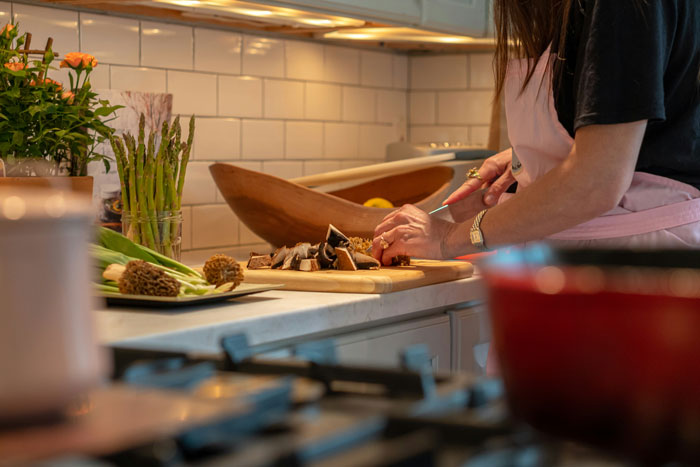 Person chopping vegetables in a kitchen, surrounded by various items, highlighting the importance of avoiding toxic kitchen elements. Person chopping vegetables in a kitchen, surrounded by various items, highlighting the importance of avoiding toxic kitchen elements.