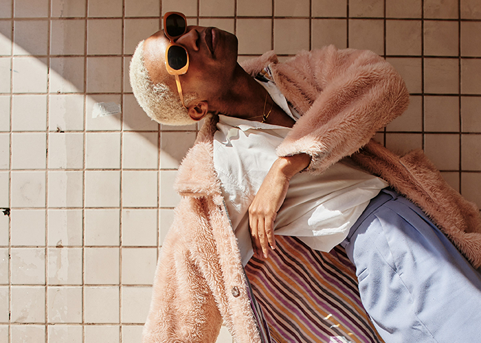 Person in a stylish outfit with sunglasses, lying on tiled floor, embodying a unique prom suit look. Person in a stylish outfit with sunglasses, lying on tiled floor, embodying a unique prom suit look.