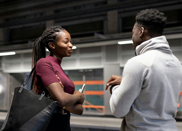 Two people in conversation at a station, discussing questions about their homeland.