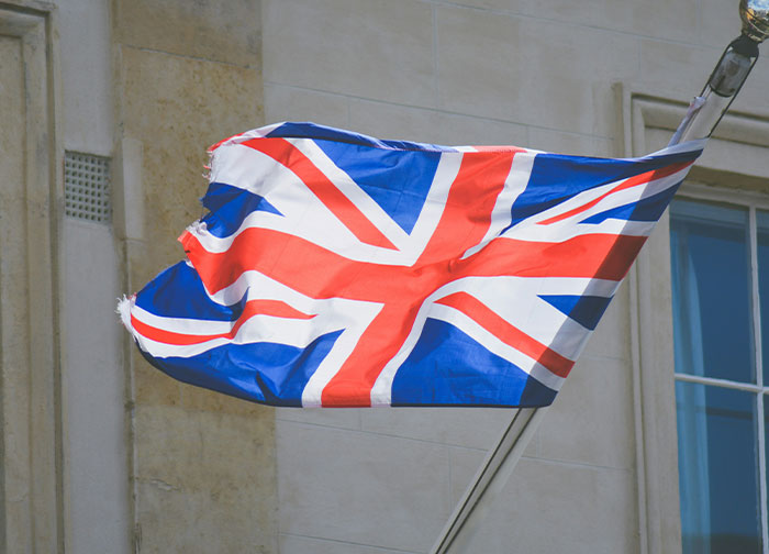 Union Jack flag waving on a building, representing homeland identity.