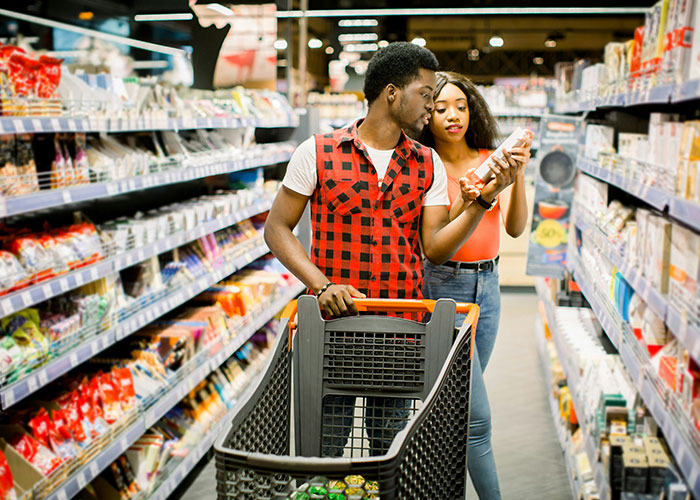 Couple walking through a grocery store aisle, using shopping as a way to reach 10K steps daily goal.