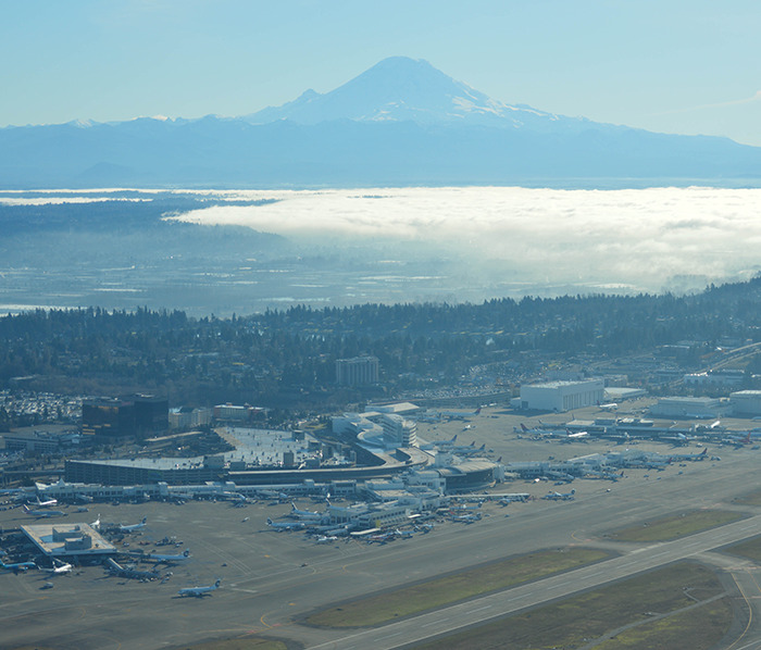 Seattle airport aerial view with planes; backdrop of distant mountains. Seattle airport aerial view with planes; backdrop of distant mountains.