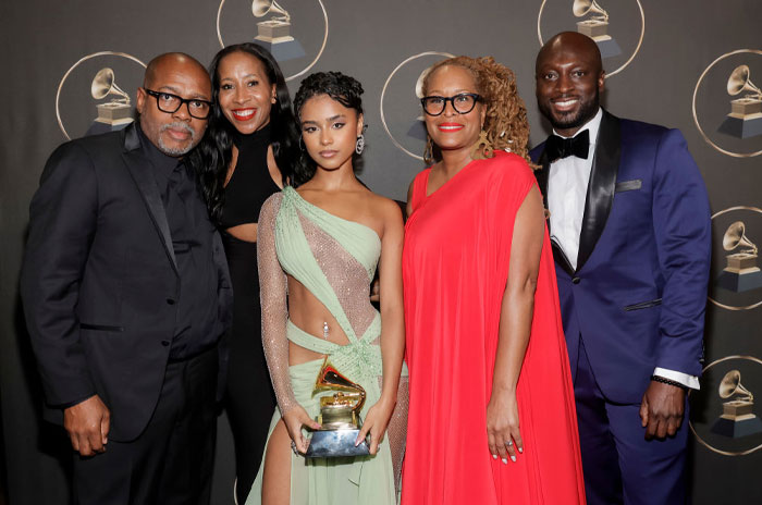 Group at awards ceremony, includes Tyla in a green dress holding a Grammy, with Sharleen and Sherwin Seethal present.