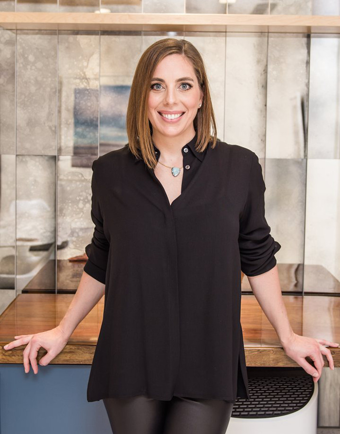 Dr. Elisabeth Potter smiling in a modern interior wearing an all-black outfit. Dr. Elisabeth Potter smiling in a modern interior wearing an all-black outfit.