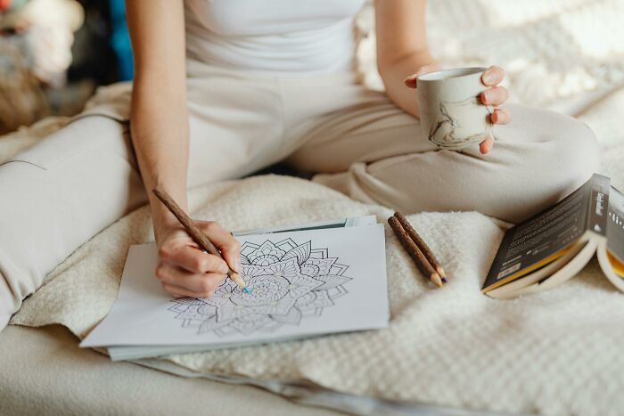 Child coloring a mandala, holding a mug; creative Valentine's gift idea for kids.