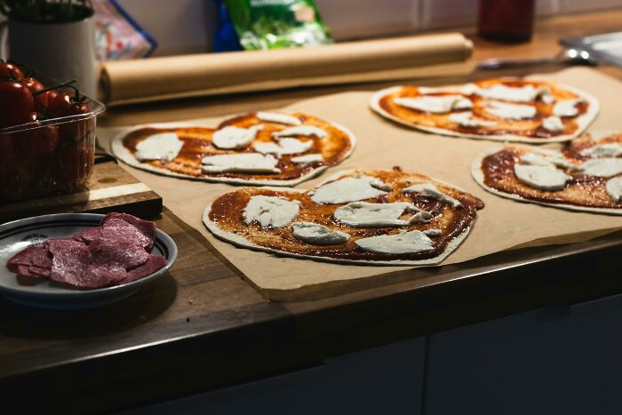 Heart-shaped pizzas with cheese, perfect Valentine's gifts for kids, arranged on a kitchen counter for a special day.