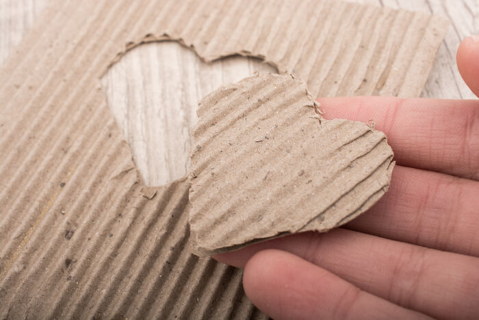 Cardboard heart cutout held by hand, symbolizing Valentine's gifts for kids.