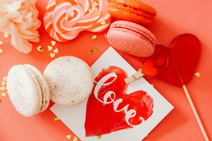 Valentine's gifts for kids: macarons, lollipop, card with "love" on a red background.