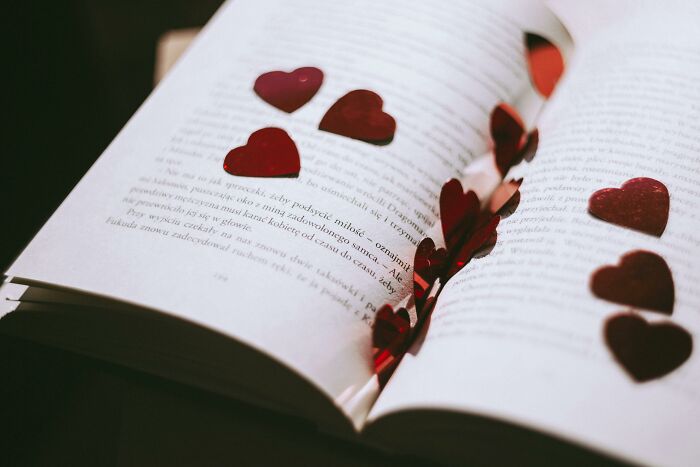 Open book with red heart confetti scattered across pages, representing Valentine's gifts for kids.