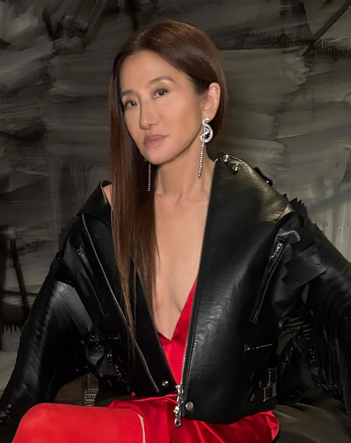 Vera Wang in a black jacket over a red dress, showcasing her bold fashion style on the red carpet. Vera Wang in a black jacket over a red dress, showcasing her bold fashion style on the red carpet.