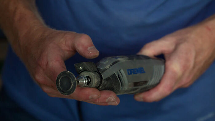 Hands holding a durable Dremel tool, showcasing its design for longevity.