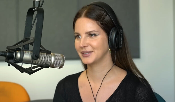 A woman with headphones speaking into a studio microphone, representing pop culture moments.