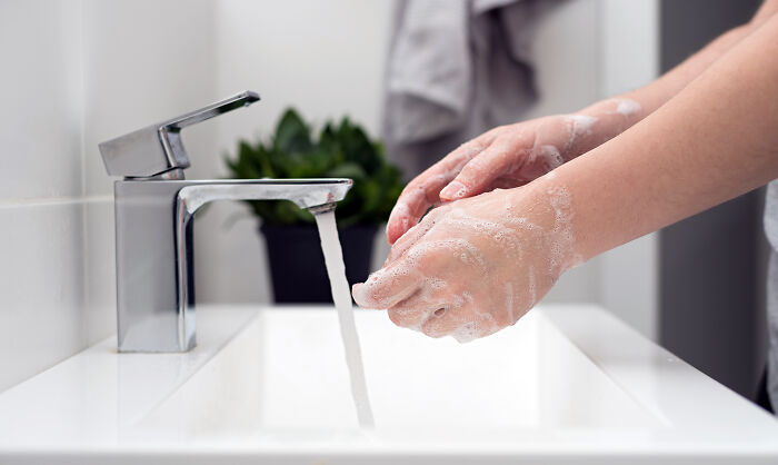 Washing hands with soap at a sink, focusing on everyday hygiene habits.